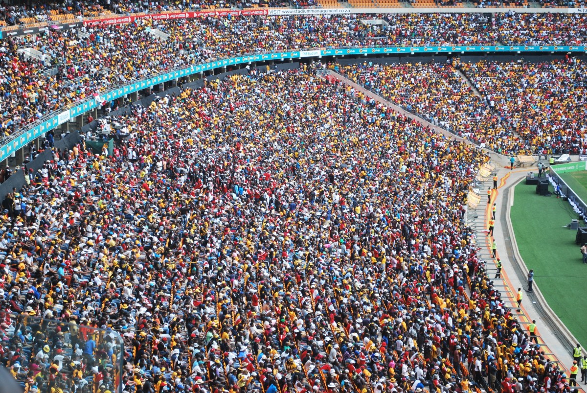 A football crowd fills the stadium stands.