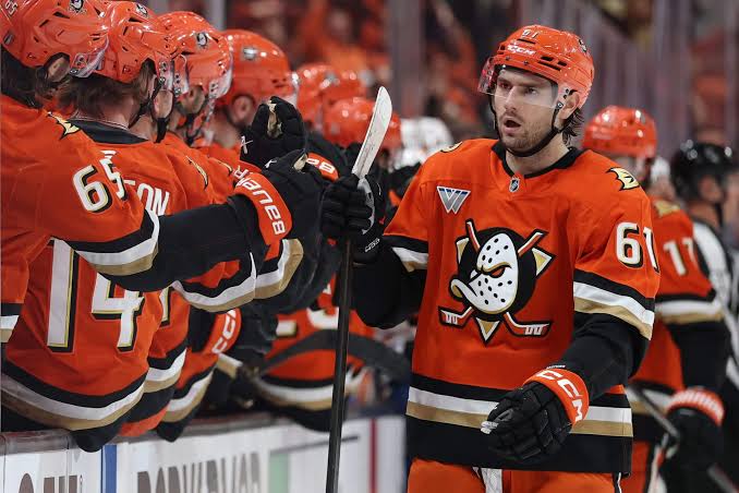 Anaheim Ducks players gather near the bench during a game.