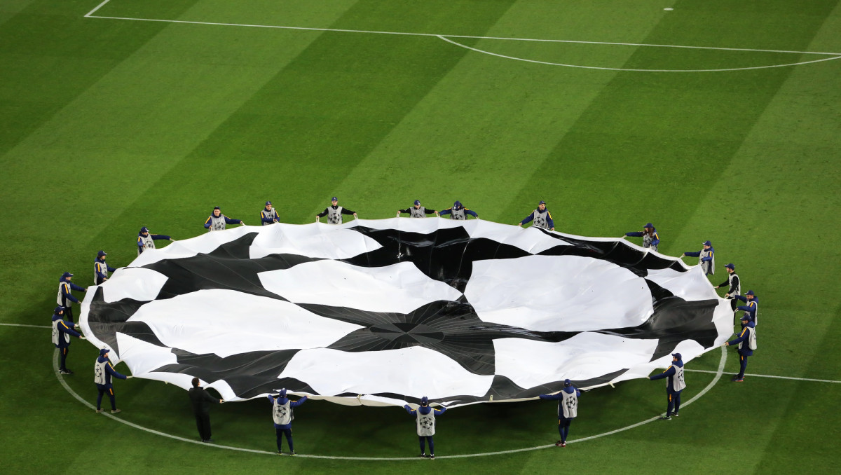 A large black-and-white banner is displayed at midfield before a soccer match